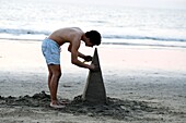 Puerto Vallarta, Mexiko; Junger Mann baut Sandskulptur