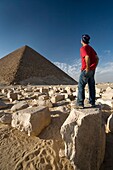 Ein Mann, der in der Nähe einer Pyramide in der Wüste steht