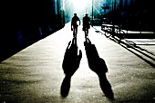 Schatten und Silhouetten von zwei Personen, die eine Straße entlanggehen; Brasilien
