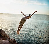 Junge springt in den Ozean; Salvador, Bahia, Brasilien