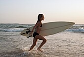 Junges Mädchen mit Surfbrett; Costa De La Luz, Andalusien, Spanien