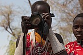 Frau vom Shompole Maasai-Stamm schaut durch eine Kamera, Kenia, Afrika