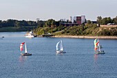 Calgary, Alberta, Canada; Sailboats On The Water With Heritage Park And The City In The Background