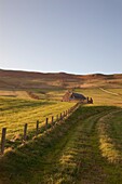 Northumberland, England; Ein Bauernhof und ein Zaun um ein Feld