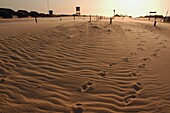 Fußabdrücke auf Sand bei Sonnenuntergang