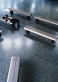 Mann auf einer Bank im Flughafen liegend