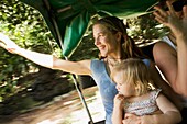 Mother With Daughter Waving Goodbye In Back Of Jeep