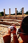 Touristen beim Fotografieren mit einer Digitalkamera im Heiligtum von Apollon Ylatis