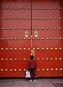 Person Peeking Through The Main Gates To The Forbidden City