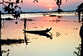 Silhouetted Person auf einem Boot auf dem Mekong-Fluss bei Sonnenuntergang