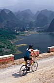 Frau beim Radfahren mit Karstlandschaft im Hintergrund