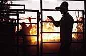 Silhouetted Cowboys Mustering Rinder auf einer Ranch