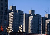 Chinesische Schrift und Blöcke von Wohnungen am Stadtrand von Peking