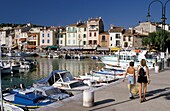 Two Women Walking Along The Harbor At Cassis