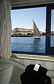 Felukenboot auf dem Nil durch das Fenster eines Kreuzfahrtschiffes gesehen