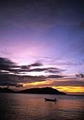 Silhouetted Boat On Sea At Sunset