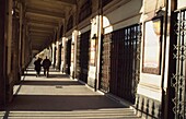 Couple Walking Down Hallway At Place Du Palais Royal