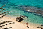 Frau auf dem Weg zum Wasser am Sandstrand