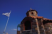 Kleine Kirche und griechische Flagge