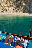 Junges Paar entspannt sich auf einer Yacht in der Nähe eines Strandes im Ionischen Meer.