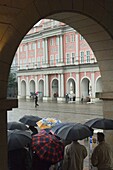 Menschen, die sich vor dem Regen auf dem Neuen Markt schützen