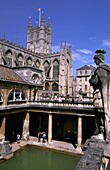 Skulptur in Great Bath mit Bath Abbey im Hintergrund