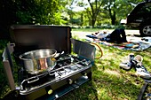 Woman Lying Down At Campsite With Stove In Foreground