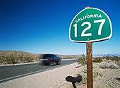 Auto und Straßenschild in der Mojave-Wüste