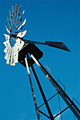 Metallische Windmühle gegen blauen Himmel