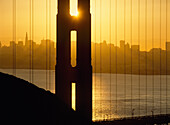 Sonnenaufgang hinter der Golden Gate Bridge mit der Skyline dahinter