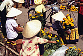 Frauen mit konischen Hüten auf dem Markt von Ho-Chi-Minh-Stadt