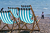 Deck Chairs Along Pebbled Beach At Brighton