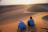 Tourist und Berber bei Sonnenuntergang, Sanddünen