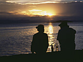 Paar bei Sonnenuntergang auf der Insel Domwe bei einem Sundowner-Drink