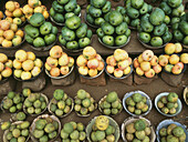 Stapel von Mangos und Zitronen zum Verkauf auf einem Markt