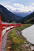 Glacier Express Zug mit Alpen im Hintergrund
