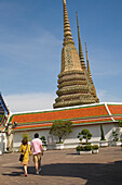 Pärchen im Wat Pho mit westlichen Hof-Chedis im Hintergrund