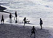 Junge Männer beim Fußballspielen am Strand