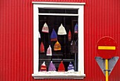 Hüte hängen im Schaufenster eines roten Gebäudes, Nahaufnahme