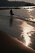 Man In Silhouette Walking Along Om Beach