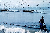 Fischer sammelt Netze am Strand