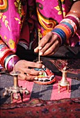 Harijan Frau in buntem Sari verkauft Räucherstäbchen