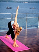 Western Woman Doing Yoga On A Cruise Boat