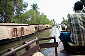 Einheimischer Mann steuert Hausboot auf Backwaters
