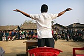 Mann leitet eine Versammlung in einem ländlichen Dorf