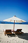 Empty Sun Loungers And Umbrella On Beach With Sea View