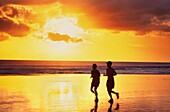 Joggendes Paar am Strand von Seminyak bei Sonnenuntergang