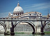 Mann rudert unter einer Tiberbrücke mit der Kuppel des Petersdoms im Hintergrund