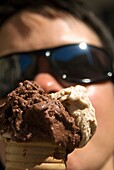 Frau mit Sonnenbrille isst ein Eis
