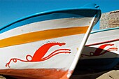 Mit traditionellen Seepferdchen-Motiven geschmückte Boote am kleinen Strand des Hafens